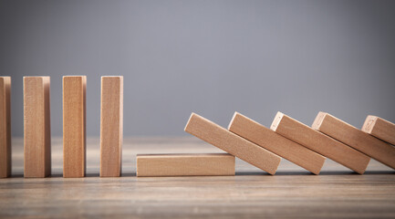Falling wooden domino. Business. Crisis. Risk