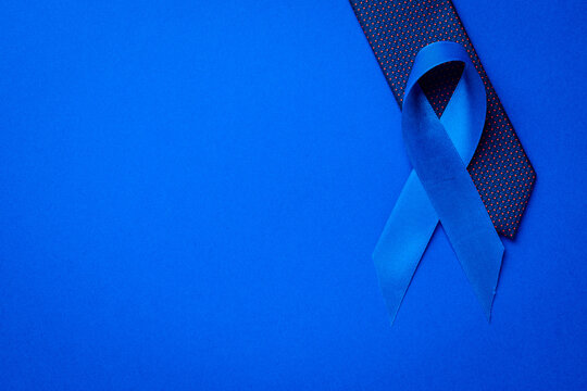 Cancer awareness blue. Blue ribbon, fashion tie isolated on deep blue background. Awareness prostate cancer of men health in November. November and International Mens Day.