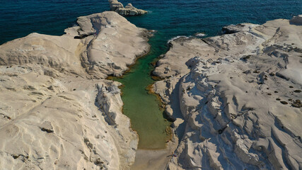 Aerial drone photo of iconic lunar volcanic white chalk beach and caves of Sarakiniko, Milos island, Cyclades, Greece
