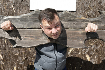 Man in wooden pillory