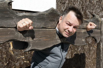 Unhappy man in wooden pillory