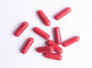 Red pills in capsules isolate on white background