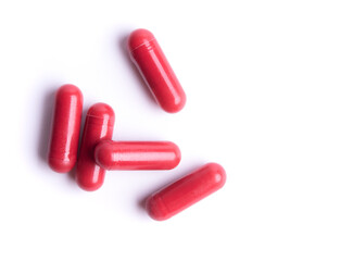 Red pills in capsules isolate on white background