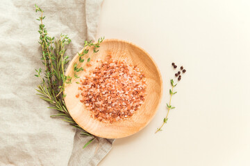himalayan pink salt granules wooden dish and thyme, tosemary and pepper. Food spices flat lay  - obrazy, fototapety, plakaty