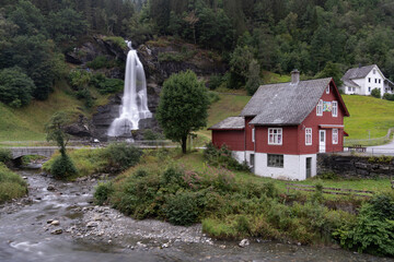 Fototapeta na wymiar Steinsdalsfossen (also Øvsthusfossen or Øfsthusfossen) a waterfall in the village of Steine in Kvam, Vestland, Norway