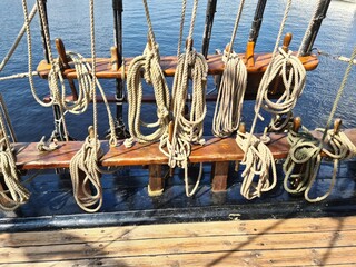 Many different ropes on an old wooden sailing ship are needed for the crew to travel the seas and...