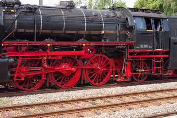 Fototapeta na wymiar Old historic steam black locomotive with red wheels at station Dieren in the Netherlands
