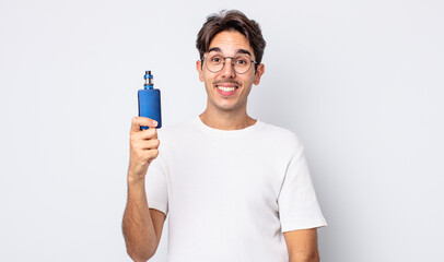 young hispanic man looking happy and pleasantly surprised. smoke vaporizer concept