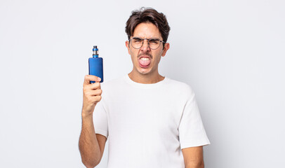 young hispanic man feeling disgusted and irritated and tongue out. smoke vaporizer concept