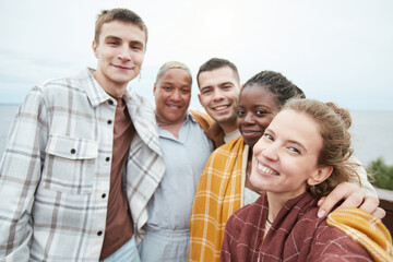 POV shot of diverse group of young friends taking selfie at viewpoint during hike, copy space