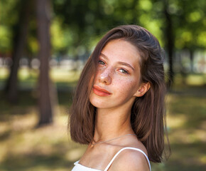 Young beautiful brown-haired girl with freckles on her face