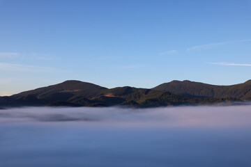 Fototapeta na wymiar Picturesque view of fog in mountains on morning