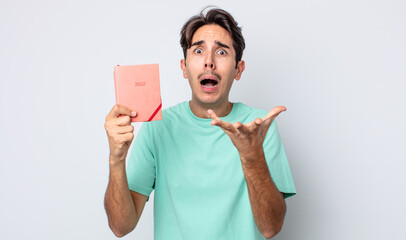 young hispanic man looking desperate, frustrated and stressed. 2022 planner concept