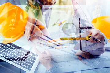 Two colleagues discussing data working and tablet, laptop with on on architectural project at construction site at desk in office