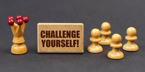 On a black background, chess and a sign with the inscription - CHALLENGE YOURSELF