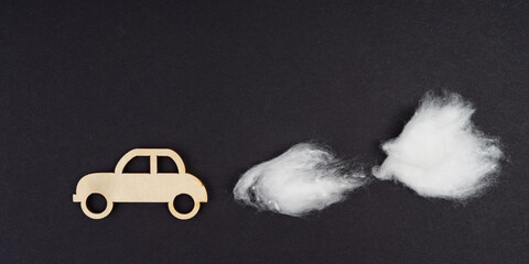 Wooden car with traces of CO-2 emissions - cotton wool. Isolated on a black background.