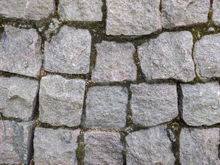 A wall of square stone slabs. Pattern. Historical feature.
