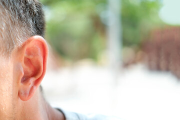 Close up of adult male ear on outdoor. Place for text. Hearing problems. Eavesdrop on gossip. Copy...