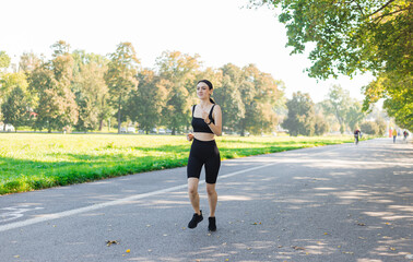 Athletic young happy woman runing in the park jogging in the morning for lifestyle health. Outdoor workout. Sport and healthy active lifestyle concept.