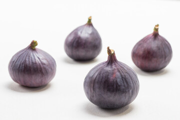 Whole purple figs. White background.