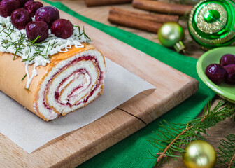 homemade biscuit cherry roll with yoghurt cream and Christmas decoration