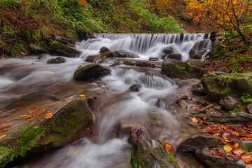 Fototapeta na wymiar Beautiful waterfall in the forest, fall season outdoor background