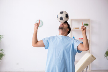Young male patient playing football in the clinic