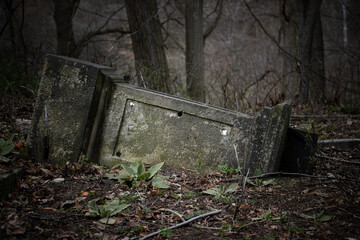 The fallen tombstone in an abandoned cemetery
