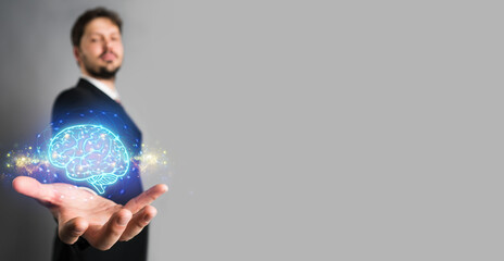 Businessman presenting an AI icon of a shining blue brain emitting energy and power on a virtual interface or computer screen