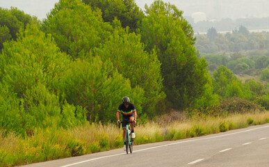 Obraz premium YOUNG TRIATHLETE RIDEING A BIKE