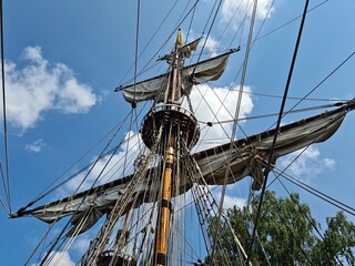 Sails collected on the yards of an old wooden sailing ship after arriving at the port