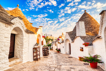 Famous Trulli Houses during a Sunny Day with Bright Blue Sky in Alberobello, Puglia - obrazy, fototapety, plakaty