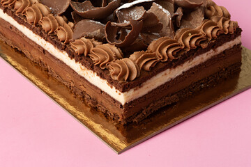 Tarta de chocolate y nata sobre fondo rosa.