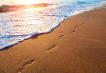 footprints on  tropical beach and beautiful  wave