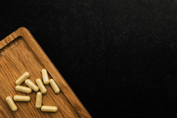 immune prevention care copy space. yellow dietary supplement capsules on wooden board and on chalkboard background