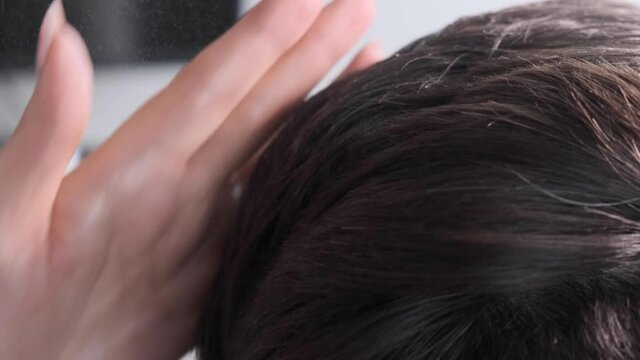 hairdresser's female hands make male hair styling. Close-up