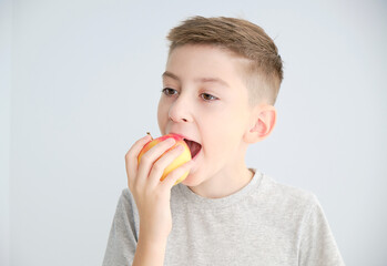 Funny Child eating apple.Little Handsome Boy with green apple. Health food. Fruits. Enjoy Meal