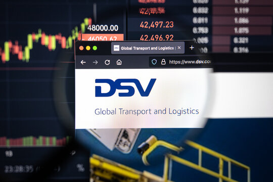 DSV company logo on a website with blurry stock market developments in the background, seen on a computer screen through a magnifying glass