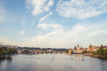 Catamarans on Vltava river near the Charles bridge at sunset light. Prague old town.