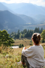 Woman enjoying beautiful mountain landscape, back view. Space for text