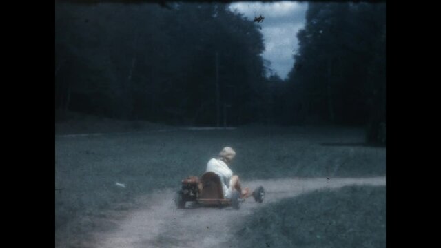 Go Kart 1958 - A young woman rides a go kart on a country path.