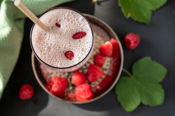Raspberry cocktail with yogurt and ice cubes on a metal plate.