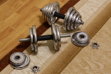Metal collapsible dumbbells on the carpet