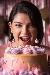 beautiful woman looking at the camera with a cake in her hands 