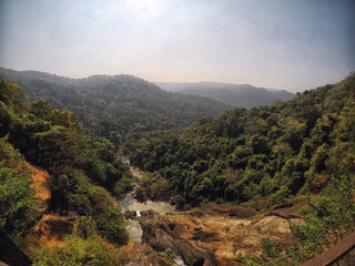 Fototapeta na wymiar View of a valley and mountains from Dudhsagar waterfall bridge located in Kulem, Goa, India