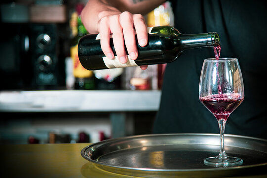 Waiter putting wine