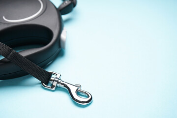 Black dog leash on a blue background, space for text, close-up.