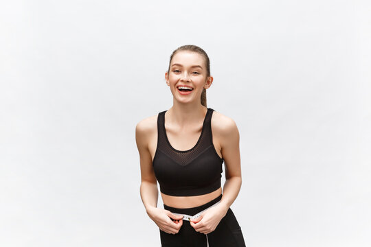 Image of a beautiful strong happy cheerful young sports woman posing isolated on grey background.