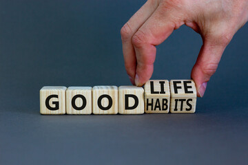 Good habits and life symbol. Businessman turns wooden cubes and changes words 'good habits' to 'good life'. Beautiful grey background, copy space. Business and good habits and life concept.