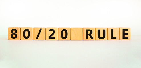 80 on 20 rule symbol. Wooden cubes with words '80 on 20 rule'. Beautiful white table, white...